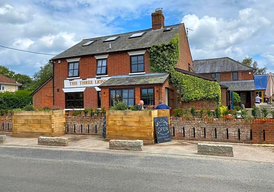 "a brick building with a sign that reads "" the three lions "" on the side of the building" at The Three Lions