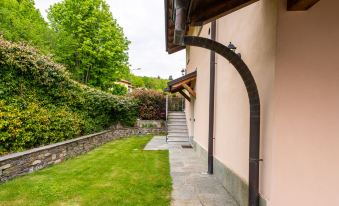 a house with a wooden roof and stone walls , surrounded by a lush green lawn at Federica