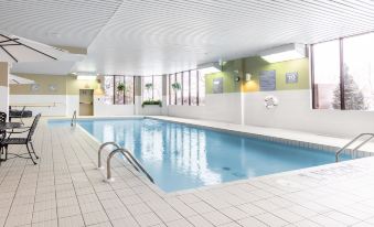 an indoor swimming pool surrounded by a building , with several people enjoying their time in the pool at Hotel WelcomInns