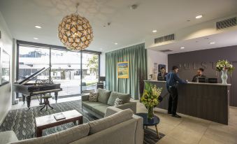 a modern office space with a reception area , couches , and a piano , as well as a man standing in the background at Quest Highbrook