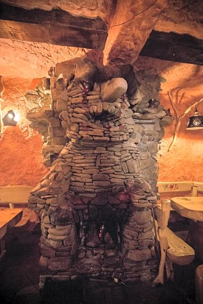 a stone oven made to look like a giant head , with fire burning inside the oven at Troll