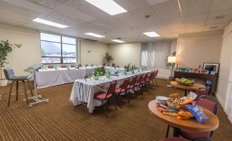 a large conference room with multiple tables and chairs set up for a meeting or event at Rodeway Inn