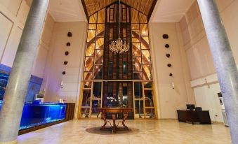 a large , modern hotel lobby with a glass elevator and a chandelier hanging from the ceiling at Aqua Safari Resort