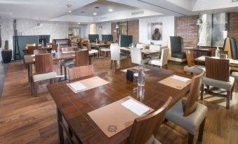 a large dining room with wooden tables and chairs arranged for a group of people at Four Points by Sheraton Saltillo