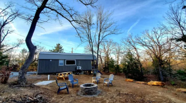 Cozy tiny cabin nested in the trees in a lake community, peaceful countryside.