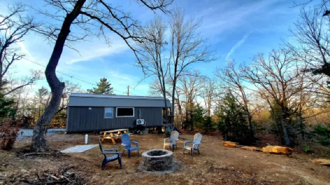Cozy tiny cabin nested in the trees in a lake community, peaceful countryside.