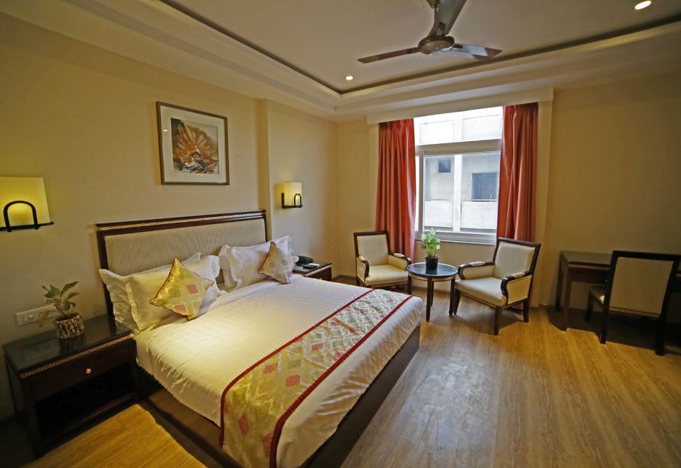 a large bed with white linens is in a room with wooden floors and chairs at Royal Inn
