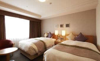 a hotel room with two beds , one on the left and one on the right side of the room at Keio Plaza Hotel Hachioji