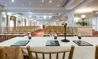 a large conference room set up for a meeting , with chairs arranged in rows and a podium at the front of the room at Garden City Hotel