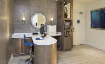 a modern office space with a curved desk , blue chair , and a white cash register at Ocean View Hotel