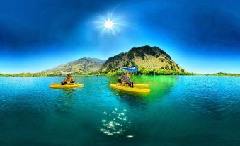 two people are kayaking on a lake with a mountainous island and blue sky in the background at Palladion