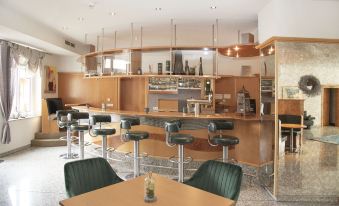 a modern restaurant with wooden tables and chairs , a bar area , and various cooking utensils at Fairway Hotel