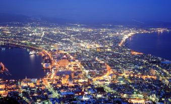 a night view of a city with bright lights and roads , set against a dark background at La Vista Hakodate Bay