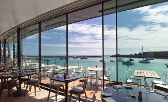 a restaurant with large windows overlooking a body of water , creating a serene and picturesque atmosphere at Rocksalt
