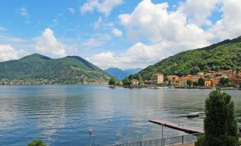 a beautiful lake surrounded by lush green trees and mountains , with a pier extending into the water at Franco