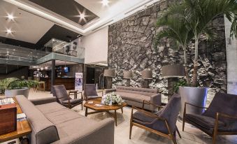 a modern hotel lobby with various seating options , including couches and chairs , creating a comfortable atmosphere for guests at Four Points by Sheraton Veracruz