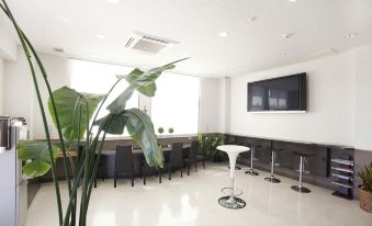 a modern office lobby with white walls , black and white checkered floors , a large screen tv , and comfortable seating arrangements at Toyota Village