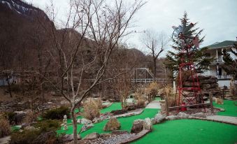 a scenic view of a park with green grass , trees , and rocks , as well as a red gazebo in the background at Broad River Inn