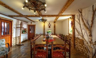 a large wooden dining table with chairs and red cushions in a room with wooden beams at VeLa