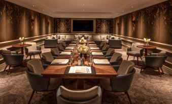 a formal dining room with a long wooden table and numerous chairs arranged around it at Four Seasons Hotel Hampshire