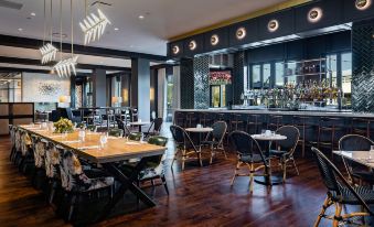 a modern restaurant with a bar and dining area , featuring a variety of tables and chairs at Crowne Plaza North Augusta