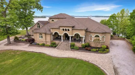 Stunning waterfront villa with indoor pool and kids swing set and play area.