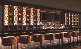 a well - lit bar area with several bottles and glasses on the counter , creating a pleasant atmosphere for patrons to enjoy drinks and socialize at The Ritz-Carlton, Marina del Rey