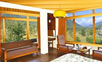 a cozy living room with wooden furniture , including a couch , chairs , and a dining table at WoodStock Hotel