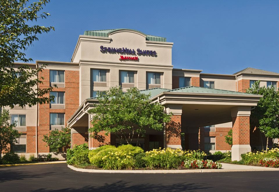 a springhill suites by marriott hotel with a large sign above the entrance , surrounded by trees and greenery at SpringHill Suites Philadelphia Willow Grove