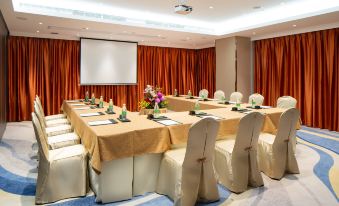 a large room arranged with long tables and chairs facing the front for an event at Holiday Inn Macau