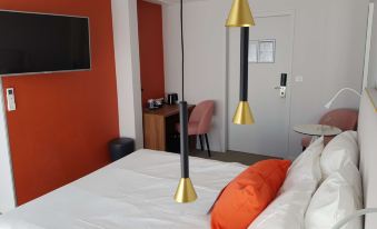 a hotel room with a bed , desk , and tv , decorated in white and orange colors at Kyriad Lyon Est - Saint Quentin Fallavier