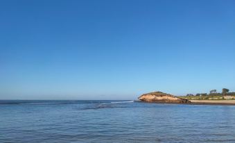 a body of water , possibly an ocean or a large lake , with a small island in the distance at Hotel Palms