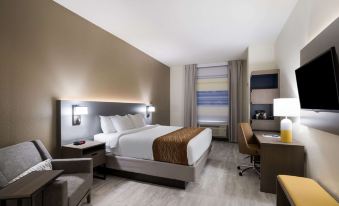 a large bed with a brown blanket is in the middle of a hotel room at Comfort Inn & Suites Victoria North