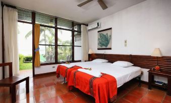 a hotel room with two beds , one on the left and one on the right side of the room at Villa Caribe