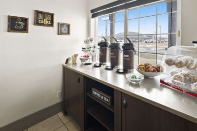 a kitchen counter with a variety of food and drinks , including coffee , tea , and fruit at Country Inn & Suites by Radisson, Watertown, SD