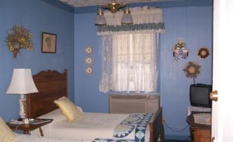 a blue bedroom with two beds , one on the left and one on the right side of the room at Hotel Strasburg
