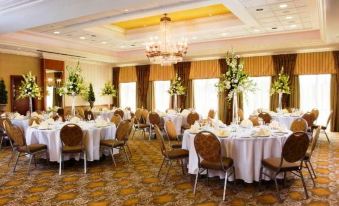 a large dining room filled with tables and chairs , where a formal event is taking place at Hotel Executive Suites