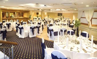 a large banquet hall with numerous tables and chairs , some of which are set up for an event at Tara Hotel