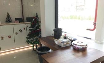 a dining table with a christmas tree and various decorations in front of a window at Klongyai Center