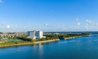 aerial view of a city with a large body of water , possibly a lake or river , surrounded by buildings and trees at Grand Mercure Lake Hamana Resort & Spa