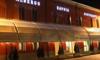 "a building with the name "" albergo savoia "" written in white letters , lit up at night" at Hotel Savoia