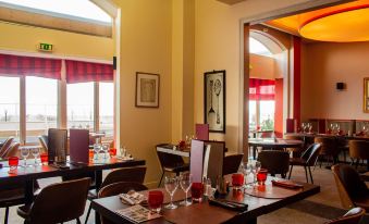 a restaurant with tables set for dinner and red lanterns hanging from the ceiling , creating a warm and inviting atmosphere at Bellevue Beaurivage