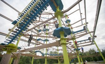 a group of people climbing on a colorful structure with ropes and ladders , possibly at an amusement park at Great Wolf Lodge Grapevine