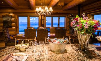 a dining room with a wooden table surrounded by chairs , and a vase of flowers placed on the table at Coyote Bluff Estate