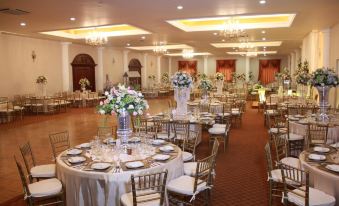 a large banquet hall filled with round tables and chairs , ready for a wedding reception at Hotel Mediterraneo