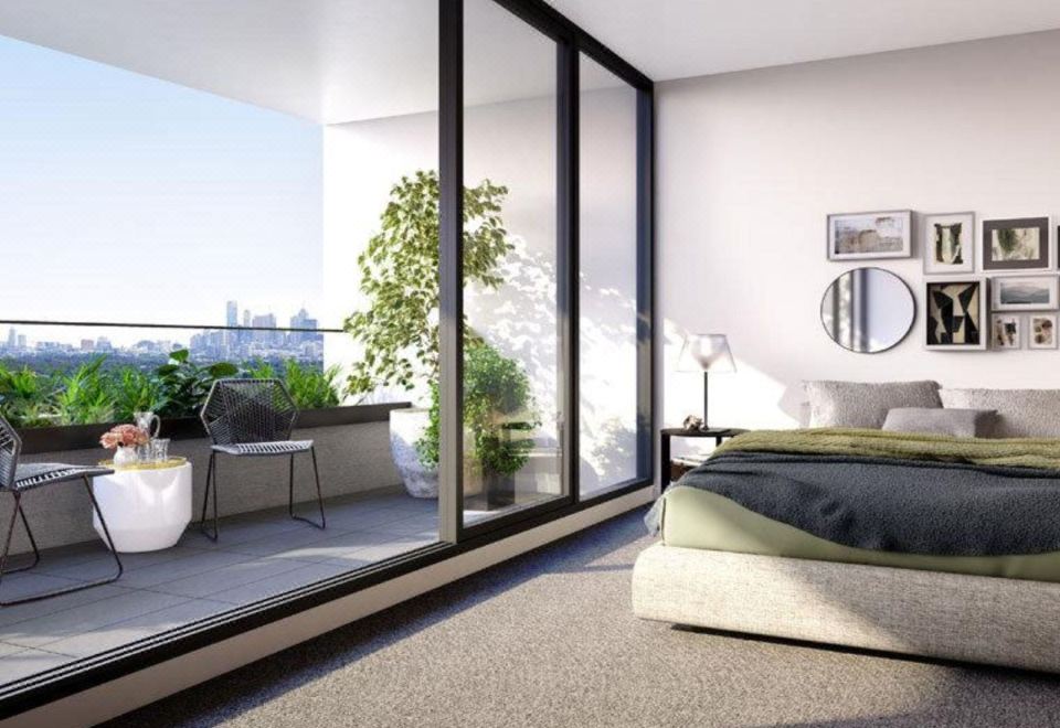 a modern bedroom with a large glass door leading to a balcony , offering a view of the city at Punthill Ivanhoe
