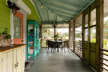 Family getaway with screened-in porch steps from surf and sun!