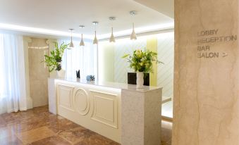a modern office reception area with a white marble counter , two potted plants , and pendant lights at Hotel Geneva by Fassbind
