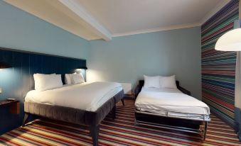 a hotel room with two beds , one on the left and one on the right side of the room at Village Hotel Chester St David's