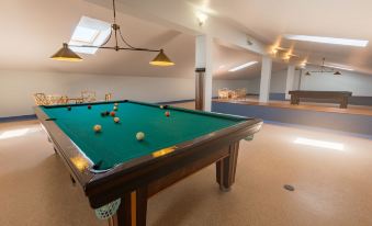 a pool table is set up in a room with chairs and a bar area at Amazonia Palmela Apartamentos Turisticos